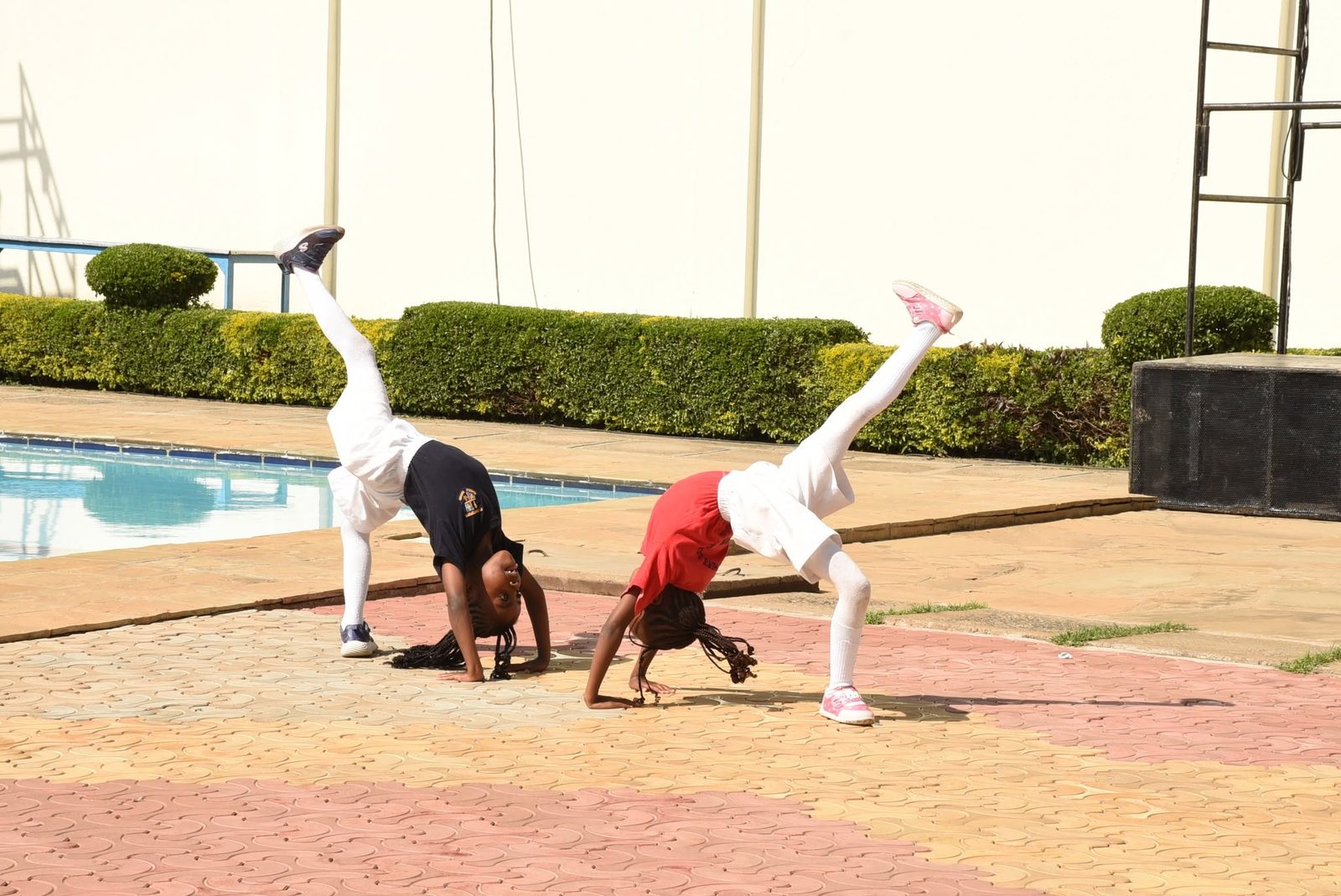 Two students performing cartwheels as part of an acrobatic display